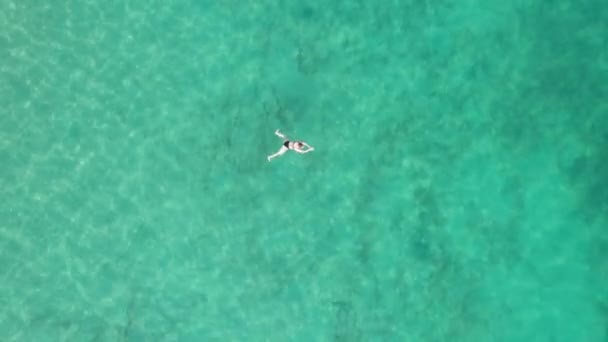 Верхній повітряний вигляд жінок - плавців на кришталево чистій воді в прозорому морі — стокове відео