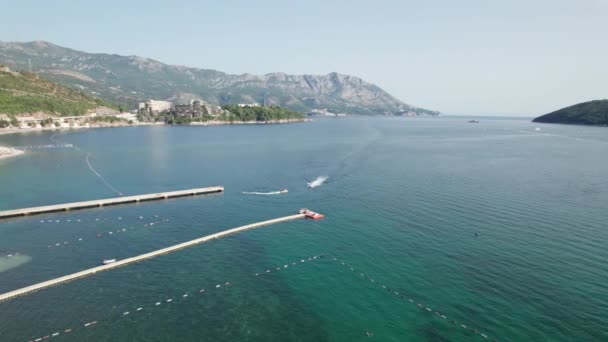 Ilmakuva Resort Sea Beachille veneillä ja vesiskoottereilla Budvassa, Montenegrossa — kuvapankkivideo