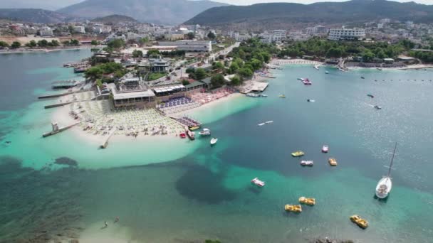 空のサンラウンジャーとボートを持つ空中, Azure Beach, Balkan Sea Coast,アルバニア — ストック動画