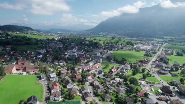 Widok z lotu ptaka na Liechtenstein z domami na zielonych polach w Alpach Mountain Valley — Wideo stockowe