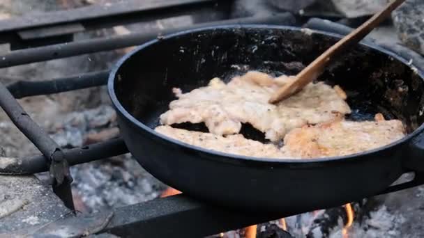 Chuletas de cerdo frito en aceite en una sartén sobre fuego al aire libre, cocinar carne grasa — Vídeo de stock
