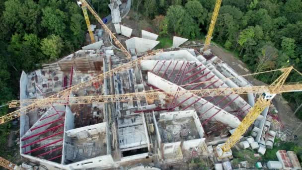 Vista aérea Construcción de un nuevo edificio con grúas de torre alta en zona verde — Vídeo de stock