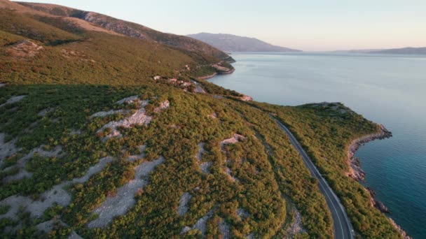 Vista aérea Paisaje Costa rocosa de Croacia con Curvy Mountain Road al atardecer — Vídeos de Stock