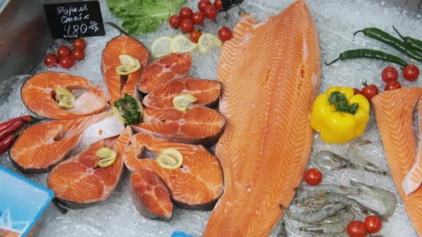 Composição de trutas e bifes de salmão jaz no gelo na mostra do supermercado — Vídeo de Stock