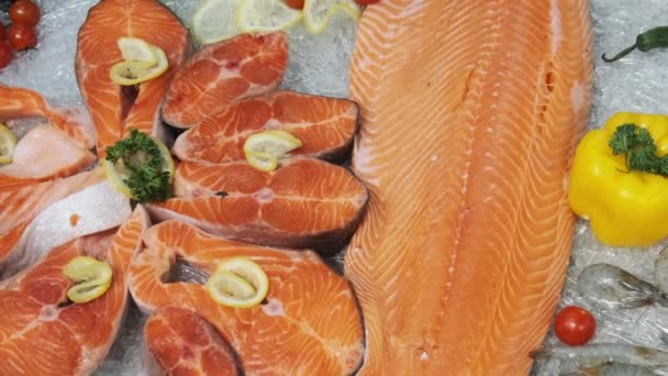 Composition of Trout and Salmon Steaks Lies on Ice in Showcase of Supermarket — Αρχείο Βίντεο