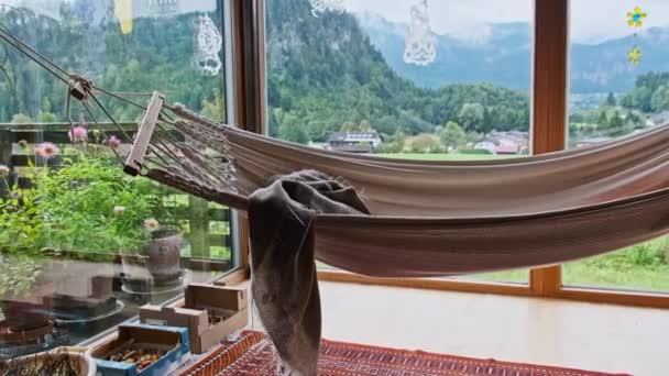 オーストリアのアルプス山脈の美しい緑の自然の景色を望む家でハンモック — ストック動画