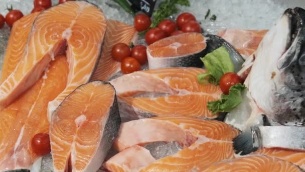 Composizione di bistecche di trota e salmone Sdraiato sul ghiaccio nella vetrina del supermercato — Video Stock