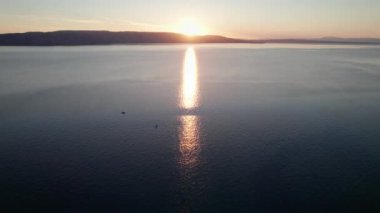 Deniz üzerinde Günbatımının havadan görünüşü Su üzerinde Yapraklar ve Parıltı