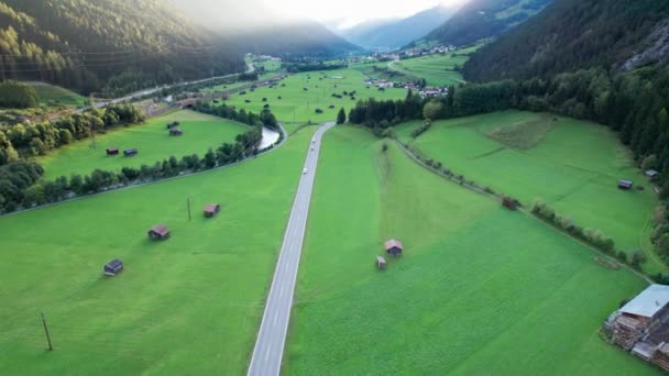 Road in Austrian Alp Valley Between Green Fields and Wooden Houses, Aerial view — Αρχείο Βίντεο