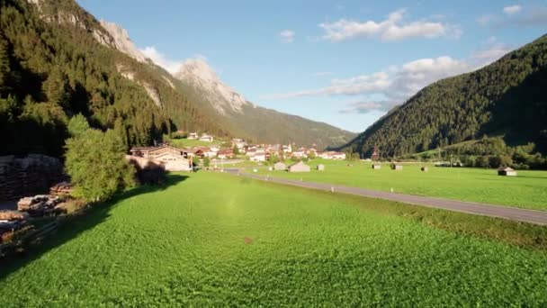 Vista aérea de un pueblo austriaco en un valle verde de la montaña al atardecer, Alpes — Vídeos de Stock