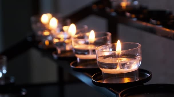 Свечи внутри церкви, зажжение молитвенных свечей в ряд, духовность — стоковое видео