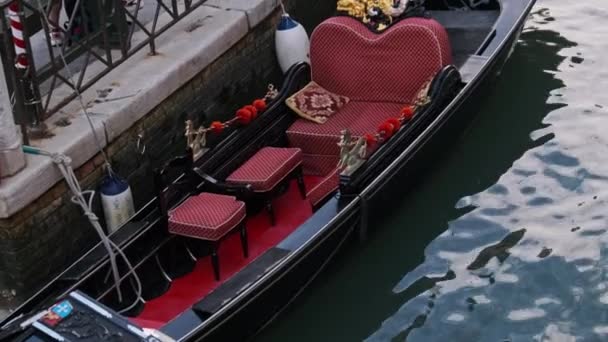 Smala kanaler i Venedig med gondoler parkerade på vatten mellan färgglada hus — Stockvideo