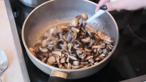Гриби смажать у паузі на домашній кухні, готуючи гриби Джульєнна — стокове відео