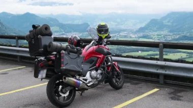 Bagajlı motosiklet Alp Dağları ve Lihtenştayn 'ın yanında duruyor.