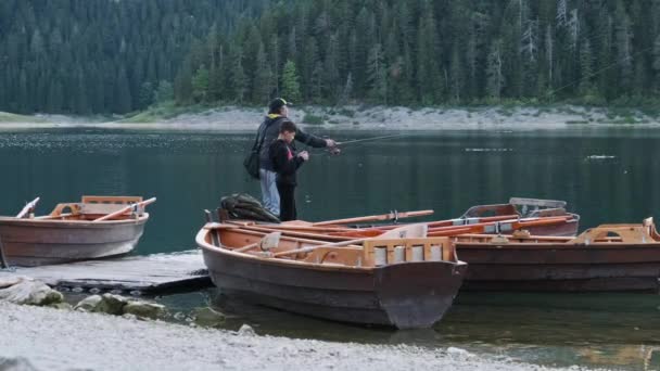 Vader en zoon vissen vanaf houten boot op het Zwarte Meer in Montenegro — Stockvideo