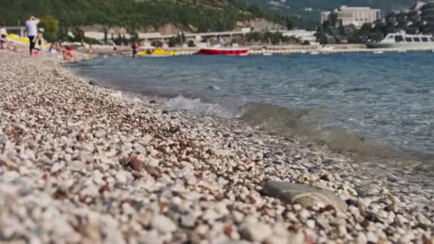 Klidný okraj vody na oblázkové pláži na slunečném dni — Stock video