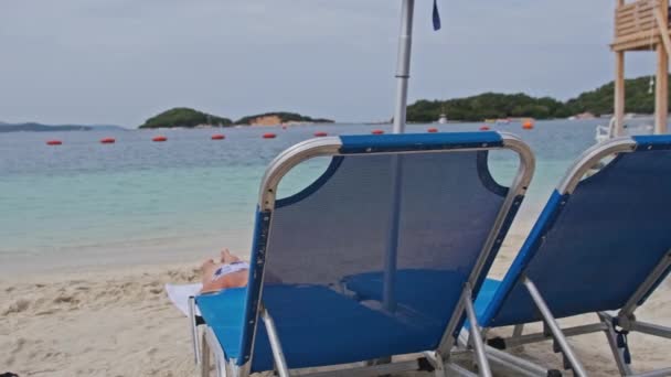 Reposeras vacías en la playa de arena contra el mar Turquesa, Albania, Ksamil — Vídeo de stock