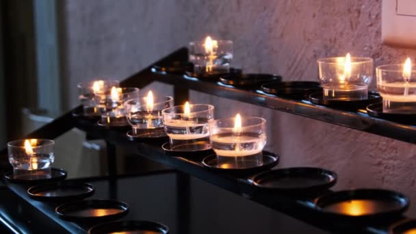 Burning Candles Inside Church Interior, Prayer Candles Lit in Row, Spirituality — Stock Video