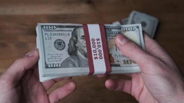 Erkek Elleri Ahşap Arkaplan Üzerindeki 10.000 Amerikan Doları Banknotları