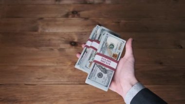 Erkek Eller 10 bin ABD Doları Dolarlık Üç Yığını Tutar ve Başparmak İşaretini Göster