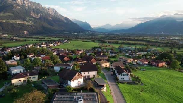 Letecký pohled na Lichtenštejnsko s domy na zelených polích v Alpách Mountain Valley — Stock video