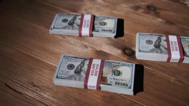 Üç deste 10000 Amerikan Doları Banknotları Tahta Masada Yatar