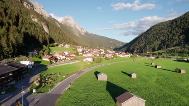 Letecký pohled na rakouskou vesnici v údolí Green Mountain Valley při západu slunce v Alpách — Stock video