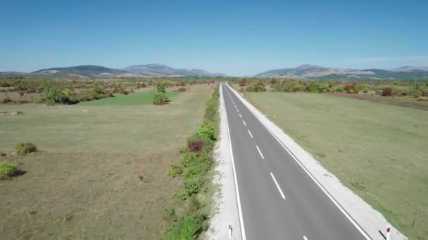 Uitzicht vanuit de lucht Lege asfaltweg op het plateau tussen groene velden, Highland Way — Stockvideo