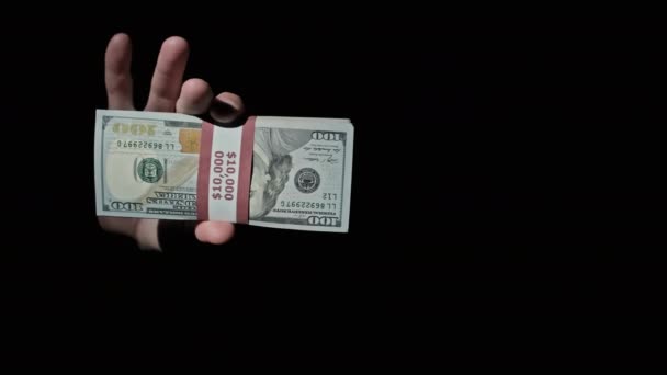 Deux piles de 10000 dollars américains faisceaux en mains masculines sur fond noir — Video