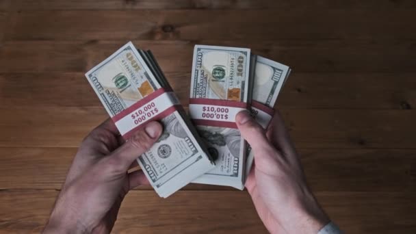 Las manos masculinas sostienen tres pilas de 10000 dólares estadounidenses y muestran el signo de pulgar hacia arriba — Vídeo de stock