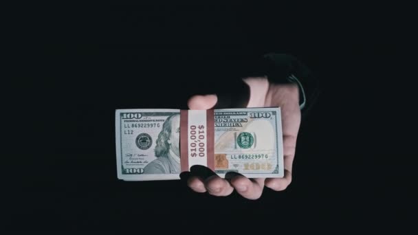 Pila de 10000 dólares americanos en paquete en manos masculinas sobre fondo negro — Vídeo de stock
