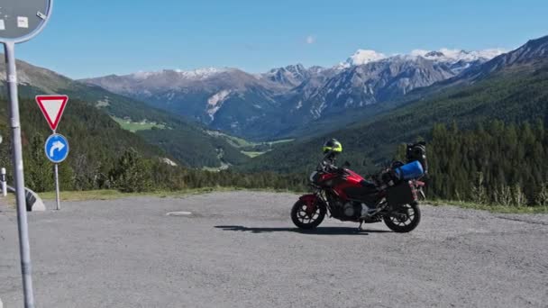 Motorka s kufry motocyklů stojí proti horské krajině Švýcarských Alp — Stock video