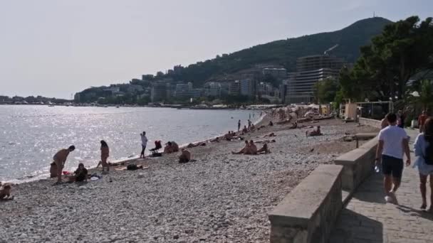 Budva strand aan zee met ligstoelen en mensen, Seashore Montenegro — Stockvideo