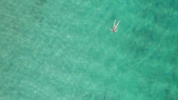 Top Down Aerial View of Woman Swims on Crystal Clear Water in a Transparent Sea — Stock Video