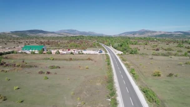 Άδεια άσφαλτος δρόμος στο οροπέδιο μεταξύ των πράσινων πεδίων, Highland Way Aerial View — Αρχείο Βίντεο