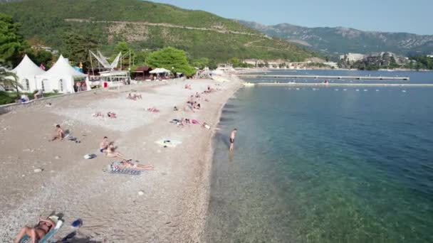 Luchtfoto Budva Strand aan Zee met ligstoelen en mensen, Seashore Montenegro — Stockvideo