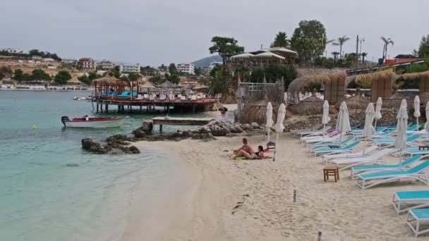 Azure Beach met ligstoelen en toeristen aan de Balkankust Ionische Zee Albanië — Stockvideo