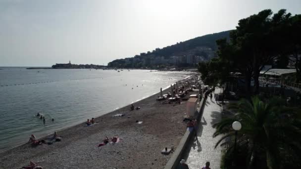 Luchtfoto Budva Strand aan Zee met ligstoelen en mensen, Seashore Montenegro — Stockvideo