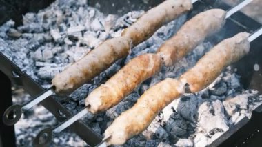 Sosisler portatif ızgarada pişiriliyor. Kapatın, barbekü.