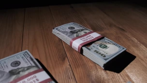 木桌上躺着三堆一万美元的捆扎钞票 — 图库视频影像