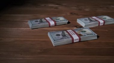 Üç deste 10000 Amerikan Doları Banknotları Tahta Masada Yatar