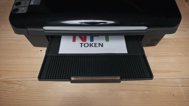 Impresión de tokens NFT, inscripción en hoja blanca de papel impresa por una impresora Jet — Vídeo de stock