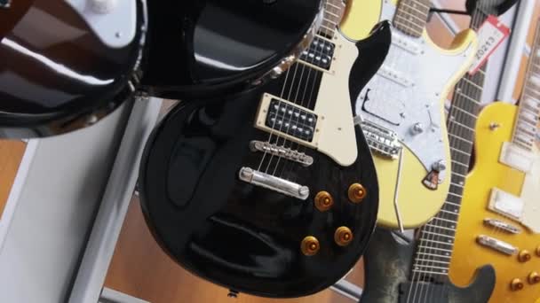 Lot of Multicolored Electric Guitars Hanging in a Music Store, Guitar Shop — Stockvideo