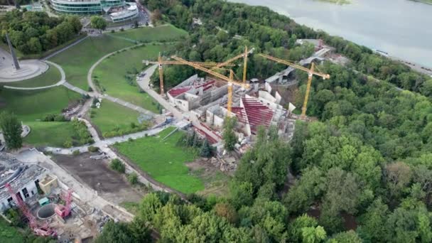 Aerial View Új épület építése magas toronydarukkal a zöld területen — Stock videók