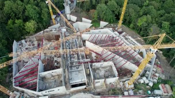 Vista aérea Construção de um novo edifício com guindastes de alta torre em área verde — Vídeo de Stock