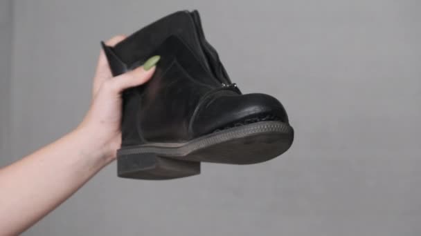 女子手拿着一只白背带扭伤的靴子，谈鞋子 — 图库视频影像