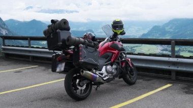 Bagajlı motosiklet Alp Dağları ve Lihtenştayn 'ın yanında duruyor.
