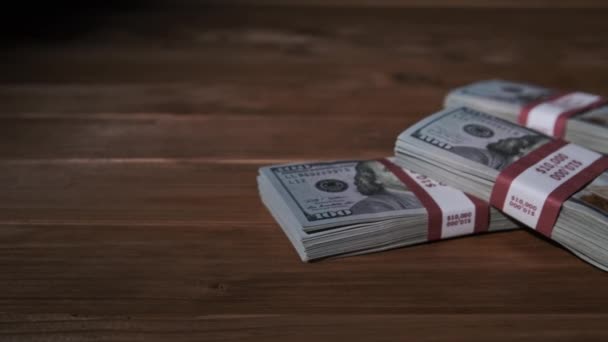 Drie stapels bankbiljetten van 10000 Amerikaanse dollar in bundels liggen op houten tafel — Stockvideo