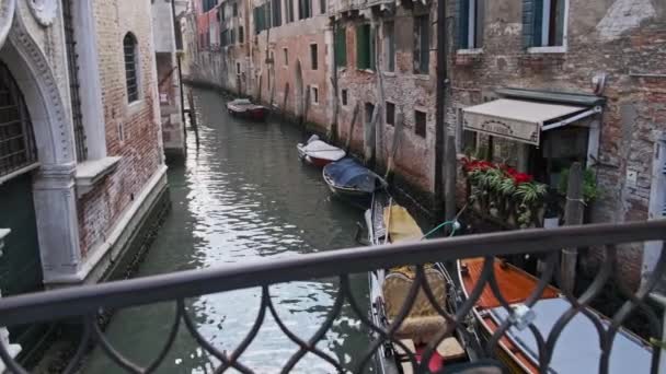 Enge Kanäle Venedigs mit auf dem Wasser geparkten Gondeln zwischen bunten Häusern — Stockvideo