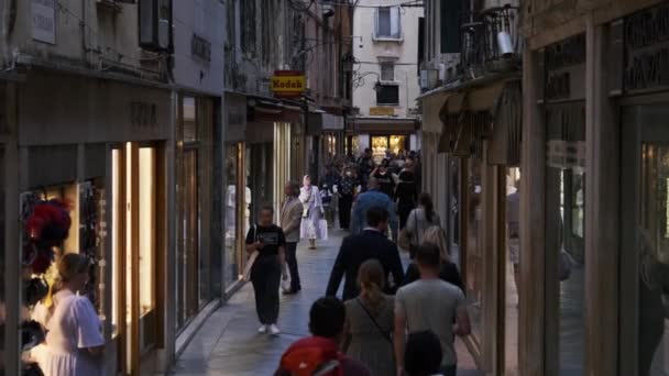 La foule se promène le long d'une rue étroite près des boutiques de souvenirs à Venise — Video